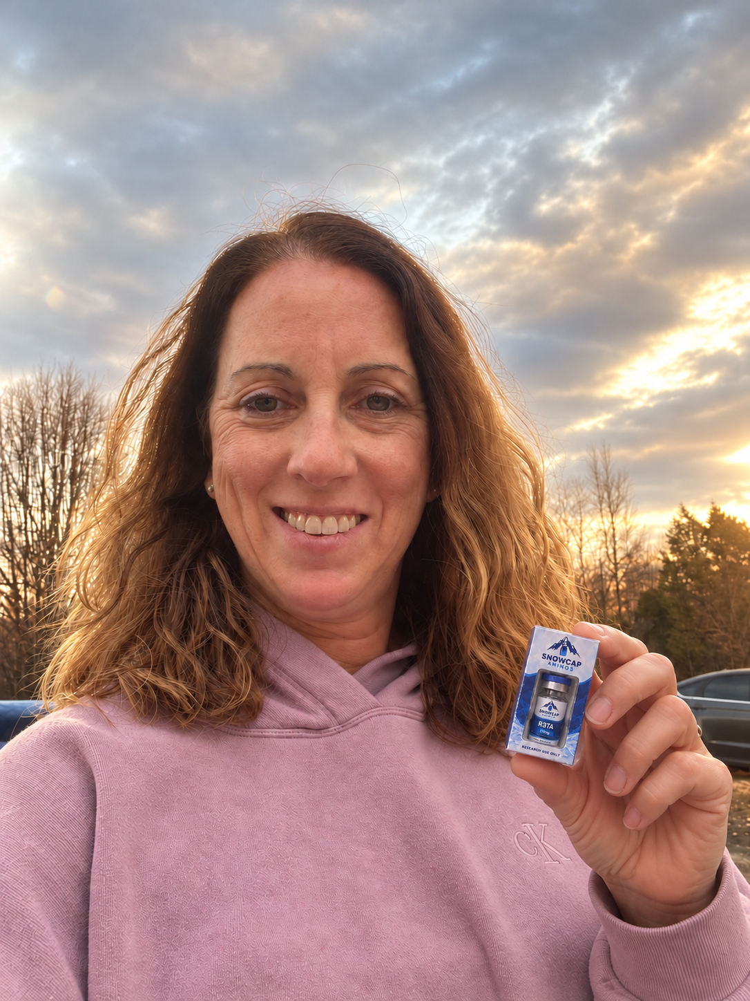 Woman holding a boxed Snowcap research vial outdoors